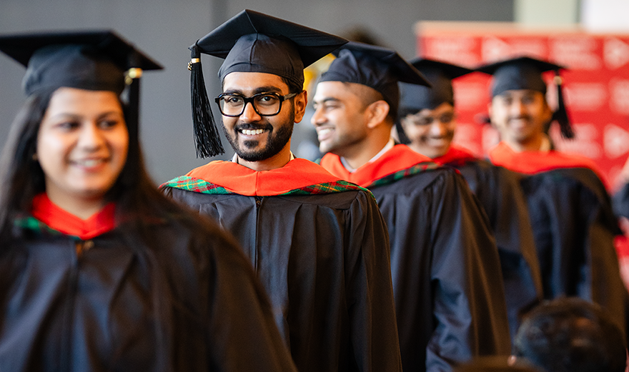 students walk at graduation